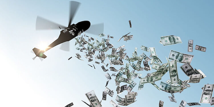 onderaanzicht van helikopter waar veel briefgeld uit gegooid wordt